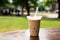 iced chai latte in a take-away cup on a park bench
