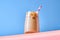 Iced Coffee with Milk in Tall Glasses on Pink Table and Blue Background. Trendy Hero View. Horizontal Orientation