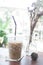 Iced coffee on table in cafe with garden outside