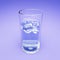 Iced colored soft drink in transparent glass on purple background