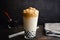 Iced Dalgona Coffee with Boba in a Pint Glass on a Dark Background