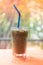 Iced Espresso coffee in a tall glass on wooden table