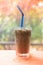 Iced Espresso coffee in a tall glass on wooden table