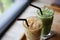 Iced green tea and coffee latte on wooden table.