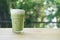 Iced green tea with milk froth on top in glass