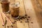 Iced iced coffee in large transparent glasses, poured over milk, with coffee beans on a wooden background, summer cooling drink,