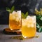 Iced kombucha drinks or homemade citrus lemonade in high glasses on grey background. Two glasses with filtered kombucha tea made