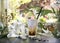 Iced latte coffee glass on table in retro restaurant and cafÃ© against the background of a window and white lilies.