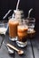 Iced layered coffee with coconut milk and condensed milk in tall glasses Vietnamese style on dark background