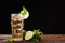 Iced lime tea in glass with mint and slice lime on wooden table