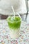 Iced Matcha green tea frappuccino in takeaway cup. Glass of green tea smoothies with fresh green tea.