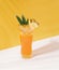 Iced pineapple punch cocktail in glass on orange background. summer drink