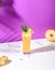 Iced pineapple punch cocktail in glass on pink background. summer drink