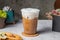 Iced Thai latte served in disposable glass isolated on wooden board side view of taiwanese ice drink