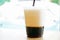 A iced two layers beverage consist of black coffee and milk in plastic cup with blurry bokeh background and copy space.