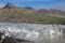 Iceland arrival of a glacier in green and brown mountain background