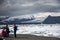 Iceland men standing at glacier lake Jokulsarlon glacial lagoon nature snow landscape Vatnajokull