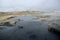 Iceland, Namafjall Hverir - pools with dirt in a steam valley