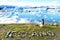 Iceland nature landscape Jokulsarlon glacial lagoon - ICELAND text written with rocks. Woman enjoying view visiting