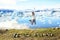 Iceland nature landscape Jokulsarlon glacial lagoon. ICELAND text written with rocks. Woman jumping having fun visiting