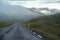 Iceland road landscape with clouds and amply field