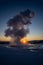 Iceland\\\'s great geyser Strokkur in full eruption with mist and smoke backlit and the orange evening or near-dusk sun