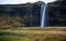 Iceland Skogafoss Waterfall Landscape with Mountain and Road. Moss on the Ground. Long Exposure