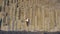 Iceland tourist at beach sitting on basalt columns Reynisfjara black sand beach