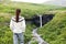 Iceland. Woman hiking looking at Svartifoss waterfall. Female is visiting famous tourist attraction of Iceland