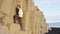 Iceland woman tourist walking on basalt columns on Reynisfjara black sand beach