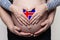 Icelandic family concept. Man embracing pregnant woman belly and heart with flag of Iceland colors closeup