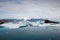 Icelandic glacial scenery, iceberg floating in the calm water, aerial shot