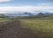 Icelandic landscape with footpath of Laugavegur hiking trail with view on Tindfjallajokull glacier, green hills and lava