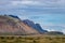 Icelandic landscape with mountains, blue sky and green grass on the foreground. West fjord part