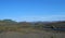 Icelandic lava desert landscape with bending river and panorama of Landmannalaugar colorful mountains and green hills