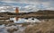 Icelandic Orange Lighthouse Reflecting in Pool of Water