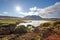 Icelandic summer nature scenery with sun, lake and mountain.