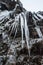 Icicle hanging from rock wall frozen