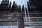 Icicle hanging from roof of rustic cabin