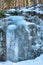 Icicle hangs from a rock in a winter nature.