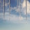 Icicles in bright sunshine against a blue sky with clouds