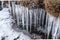 Icicles on the edge of a stream