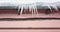 Icicles hang on roof over pink urban wall