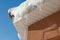 The icicles hanging from the rim of the roof. The spring background of melting ice and snow in the sunny day