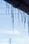 Icicles hanging from roof of house. Winter concept. Closeup danger icicles. Frozen climate pattern. Frost winter