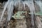 Icicles hanging from the roof of the old brick building with cubes of old tiles, traumatic acrid ice, thaw in the early spring, se