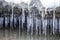 Icicles hanging from snowy stones over river water