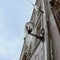 Icicles hanging from a streetlamp. Facade of the old building wi