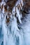 Icicles melted in the sun and bent from the wind on a rock.