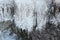 Icicles on stones at the thawing river